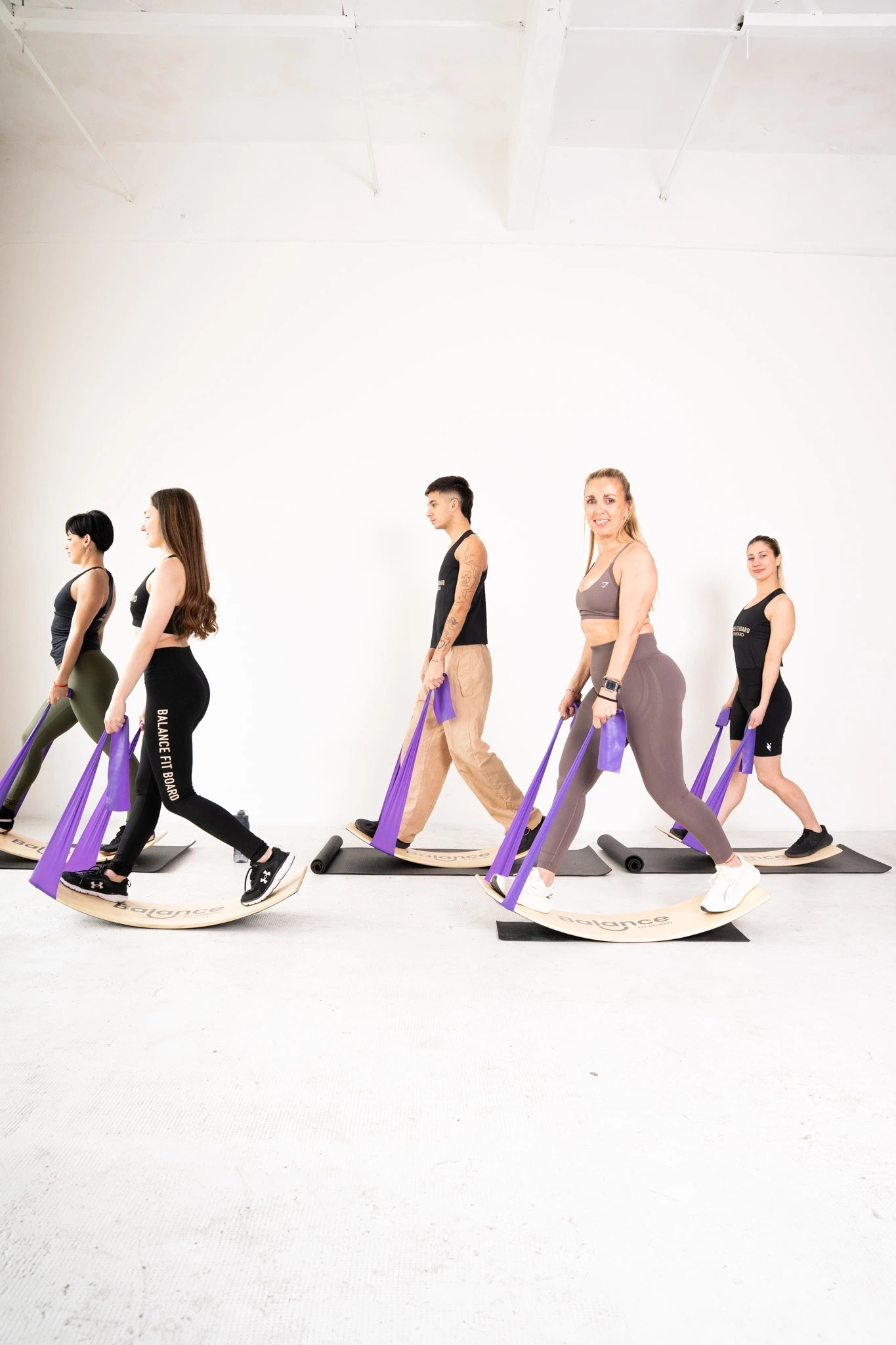 Coach guiando a una alumna durante una clase de Balance Fit Board